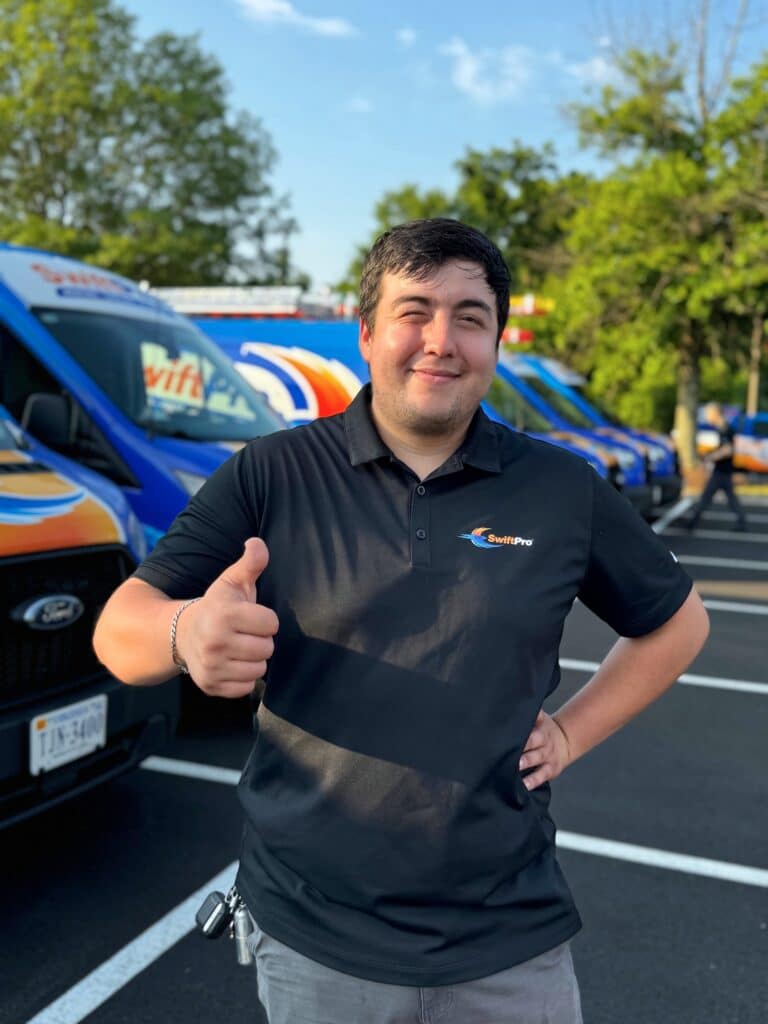 SwiftPro technician smiling and giving thumbs-up in front of company van, representing local Northern Virginia