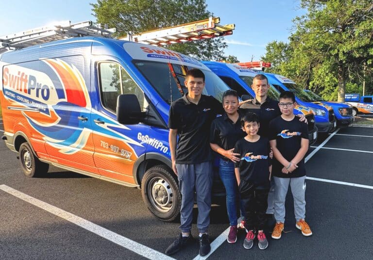 A family in SwiftPro shirts standing beside the SwiftPro vans