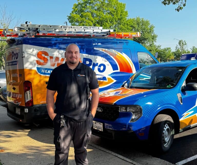 A SwiftPro technician standing beside a wrapped SwiftPro van and pickup truck in Northern Virginia