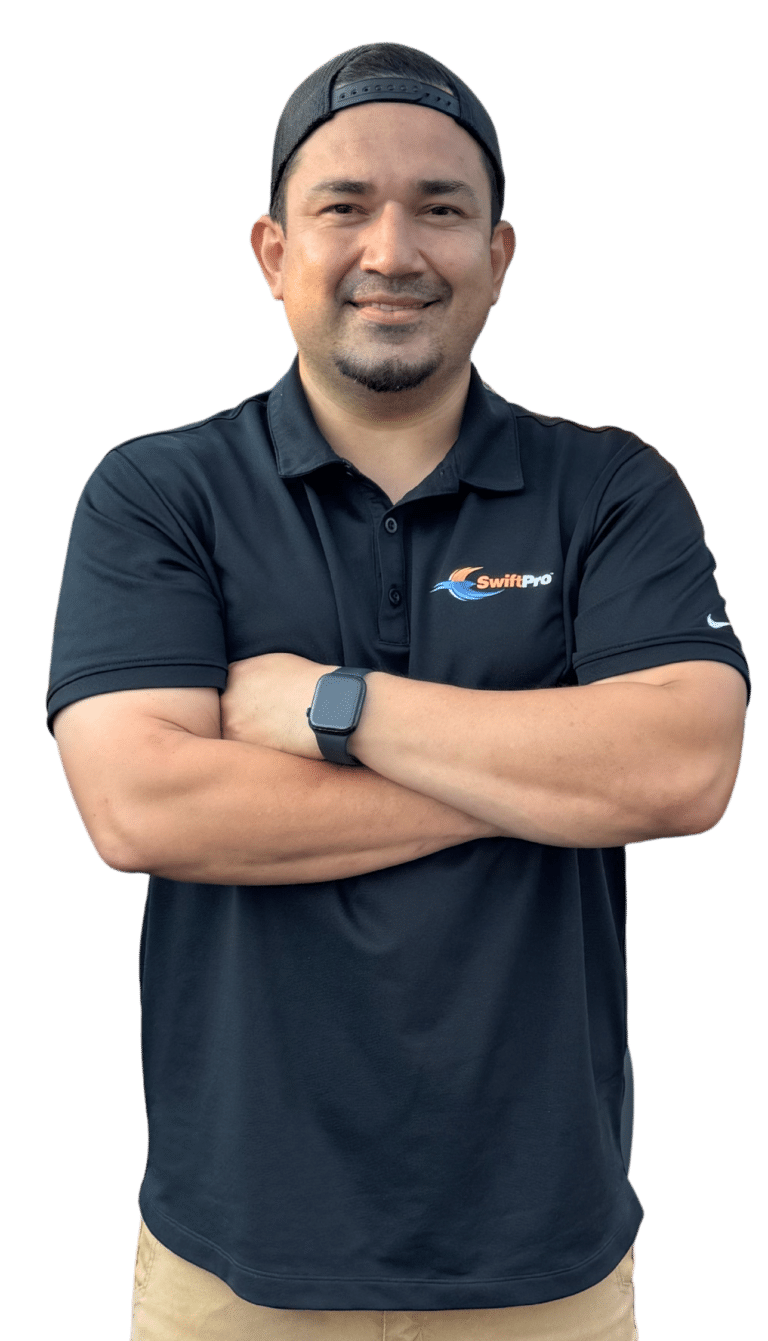 A SwiftPro HVAC technician from our Northern Virginia team in a black company polo and a backwards cap, arms crossed, on a white background