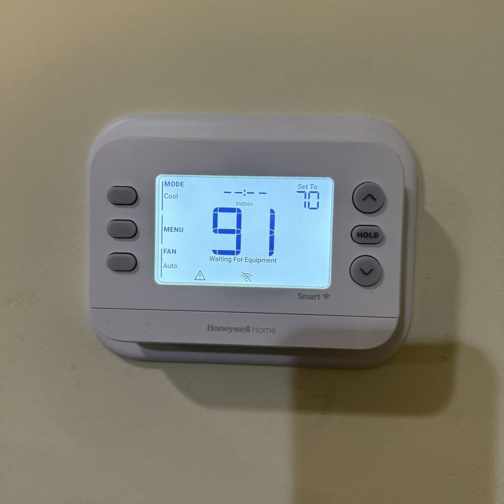 A Honeywell Home thermostat set to Cool at 70 degrees, reading 91 degrees indoors, with Waiting For Equipment on its screen