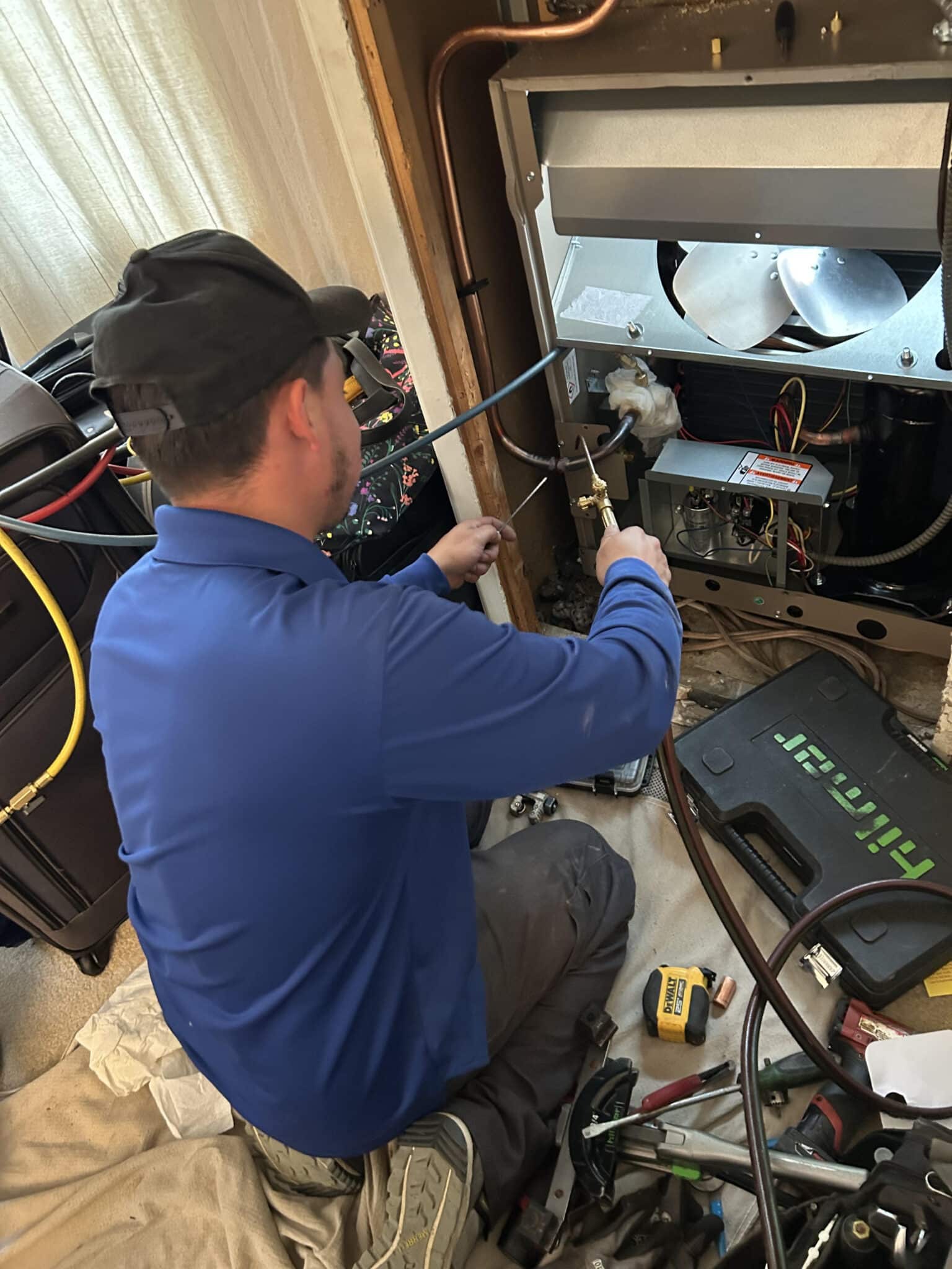 Plumber repairing commercial plumbing systems in a restaurant kitchen, showcasing efficiency