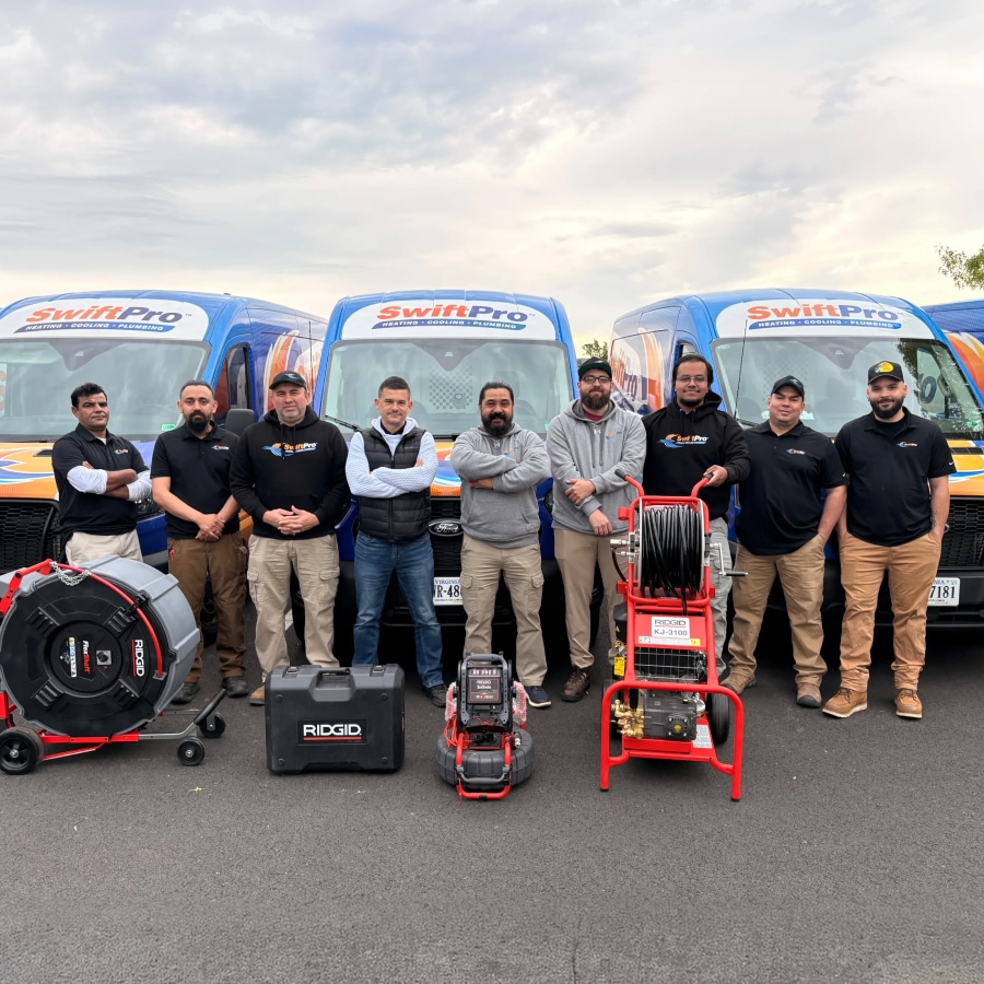 SwiftPro technicians standing in front of three SwiftPro vans with their equipment