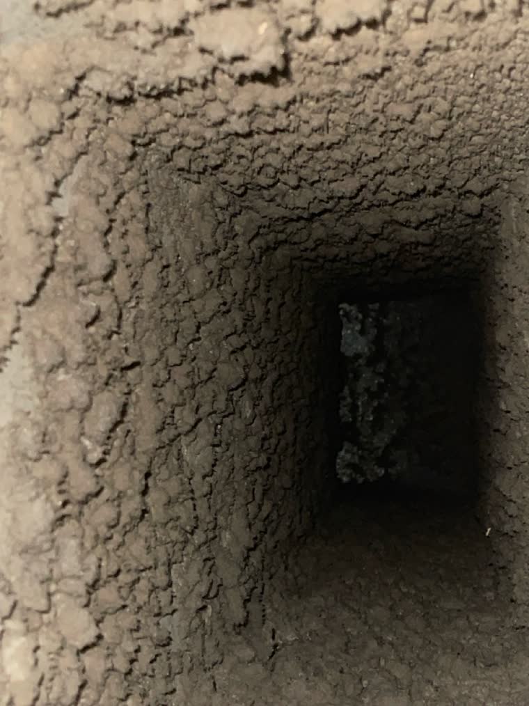 Looking down a lined supply duct in a Northern Virginia home before SwiftPro cleaned it, the walls furred over with grey dust