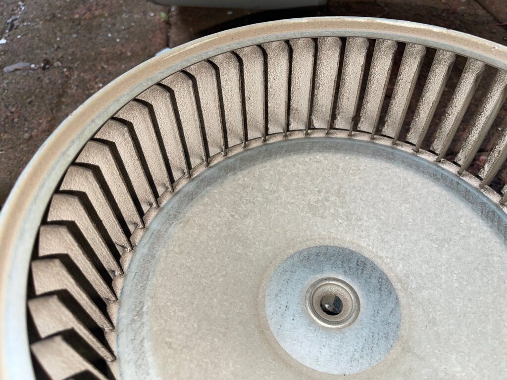 A furnace blower wheel pulled out on a SwiftPro heating job in Northern Virginia, a coat of dust packed onto every blade