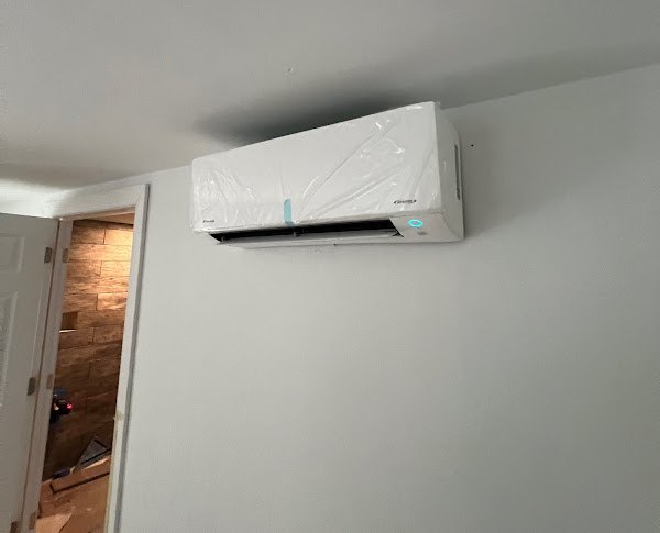 A newly installed ductless mini split head still in its protective wrap on the wall of a Northern Virginia home