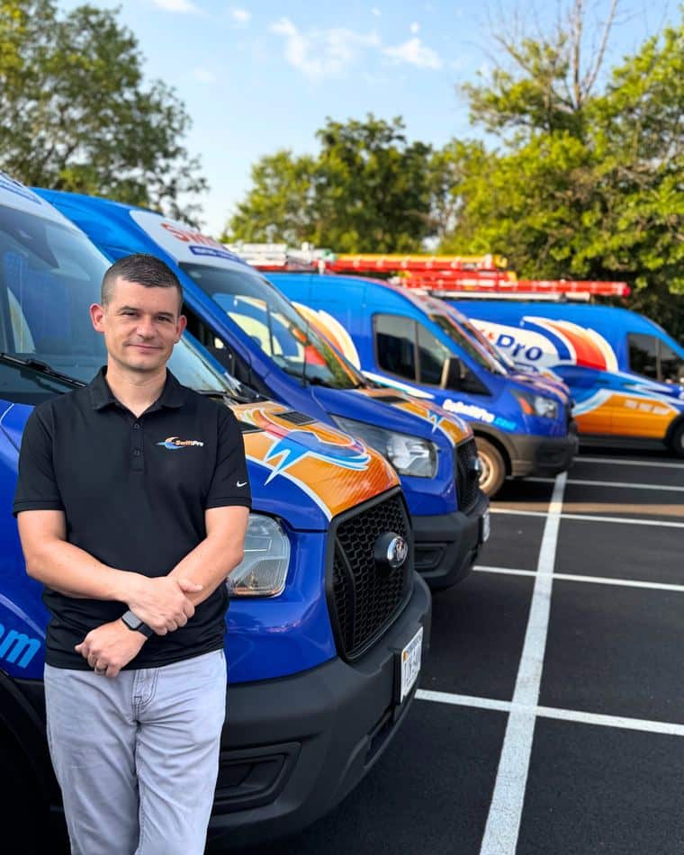 Tyler Griffin, owner of SwiftPro, beside the wrapped SwiftPro van fleet in Chantilly, Virginia