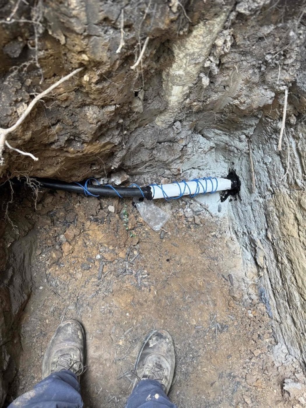 Repaired underground water service line in an open trench on a SwiftPro plumbing job in Northern Virginia
