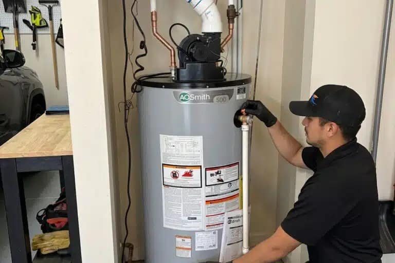 SwiftPro plumber checking the connections on a newly installed A.O. Smith power vent water heater in a Northern Virginia garage