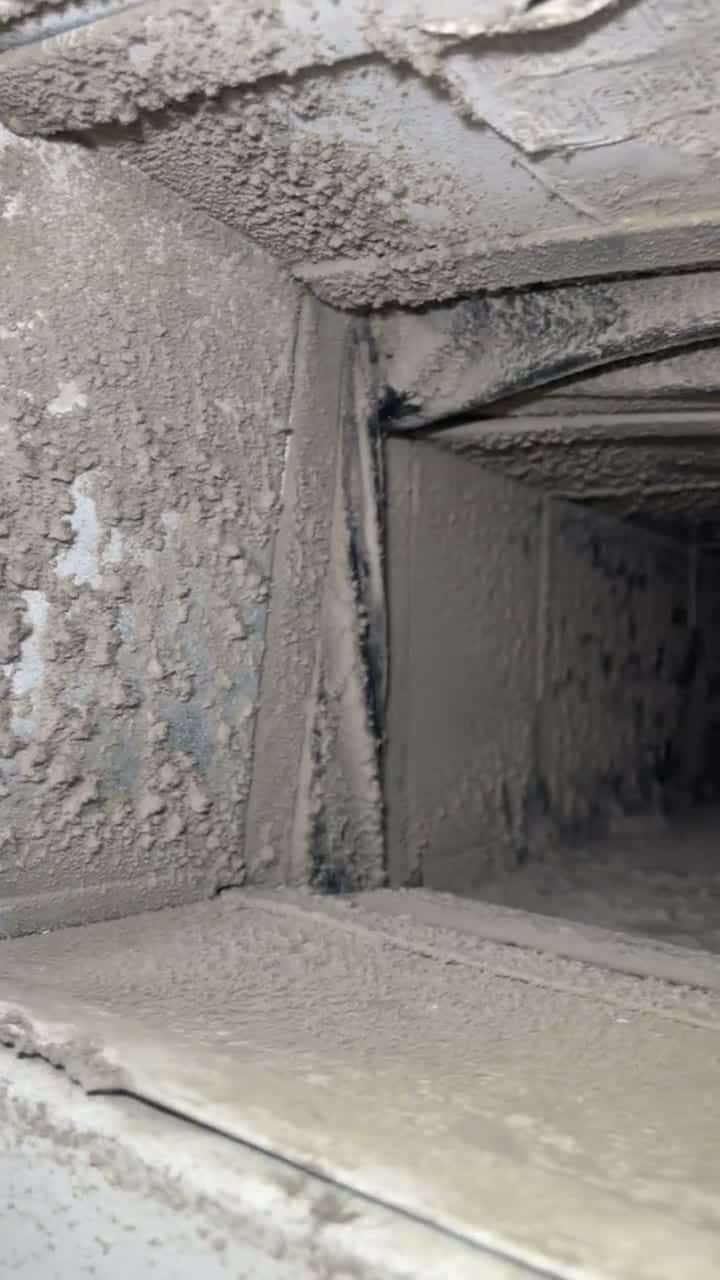 Raw phone clip, no text: thick, flaking dust buildup on a duct elbow, then a view down a dusty trunk.