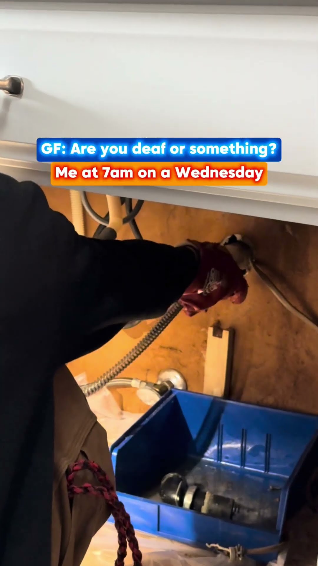 Water heater swap: a tech with a headlamp cuts metal with an angle grinder outside a brick house, then disconnects and wheels out an old GE electric water heater past a SwiftPro van.