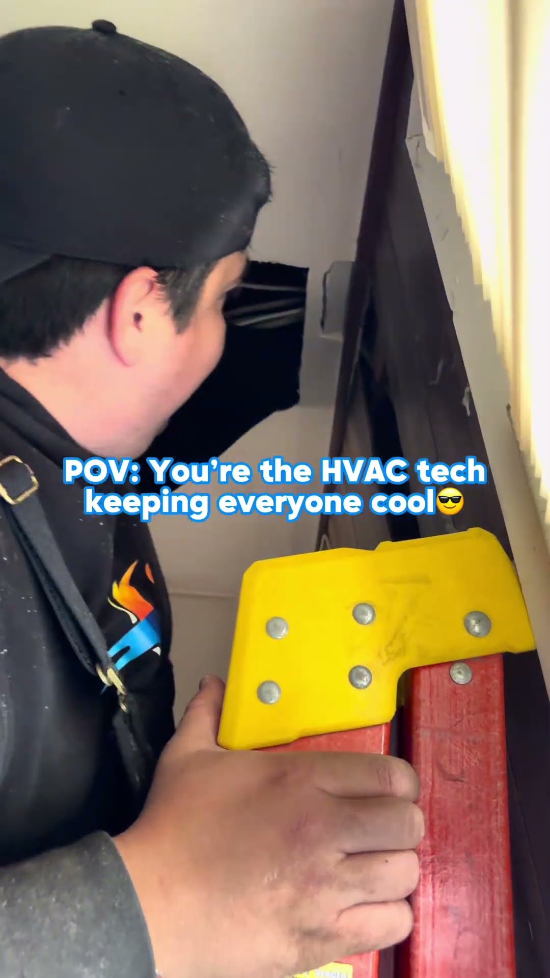 A young tech in a black SwiftPro hoodie climbs a ladder to an attic access, foil-wrapped ductwork in a dark attic, and a tech in a black cap pulls the face panel off a ceiling cassette mini-split.