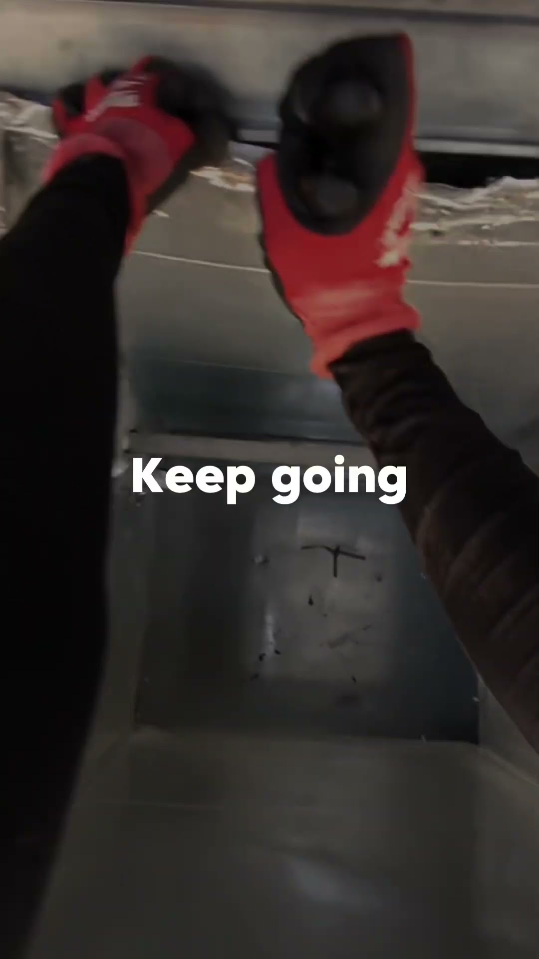 POV gloved hands cutting and bending sheet metal on an overhead plenum or duct.
