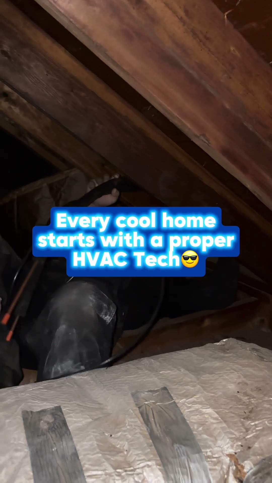Dark attic footage: a tech in a black hoodie crawls past foil-wrapped insulated ductwork under the rafters, then works at an attic air handler.