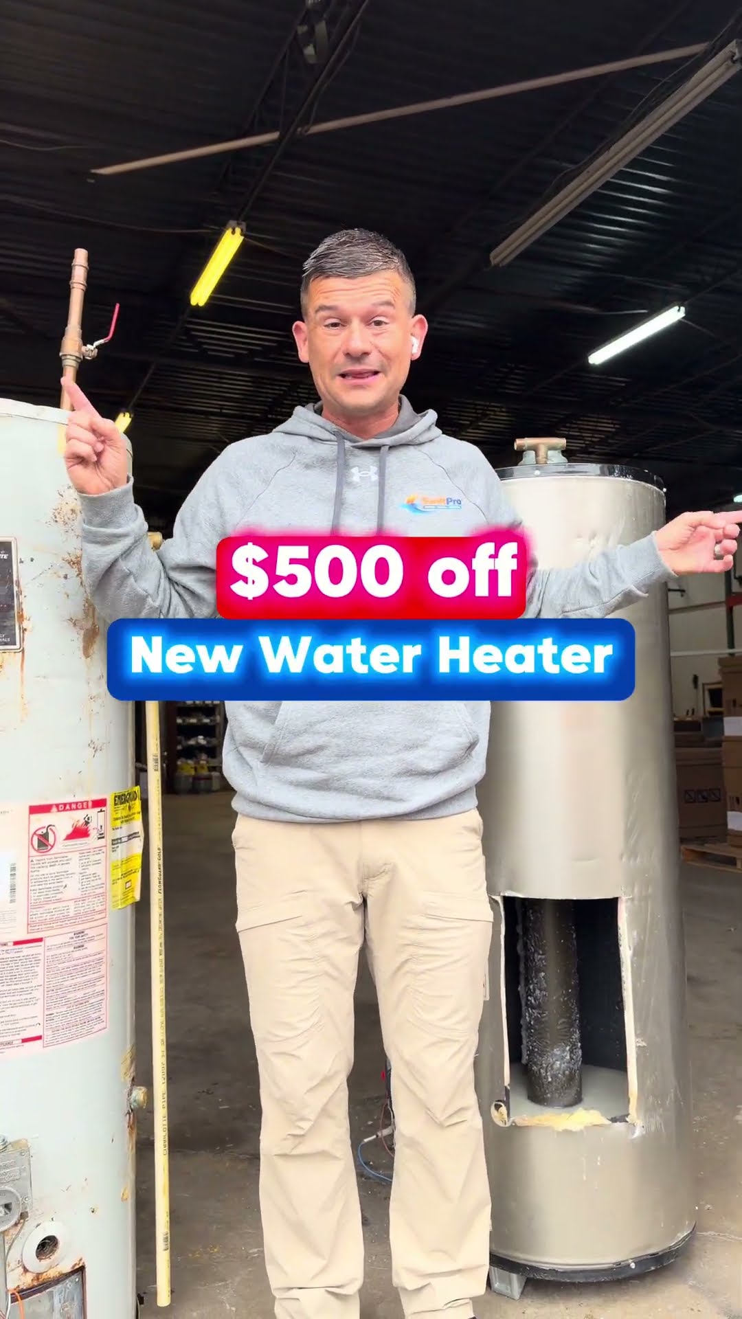 Tyler Griffin (name on screen) stands in the SwiftPro warehouse between two old tank water heaters, one cut open to show the corroded inside, with a '$500 off New Water Heater' banner.