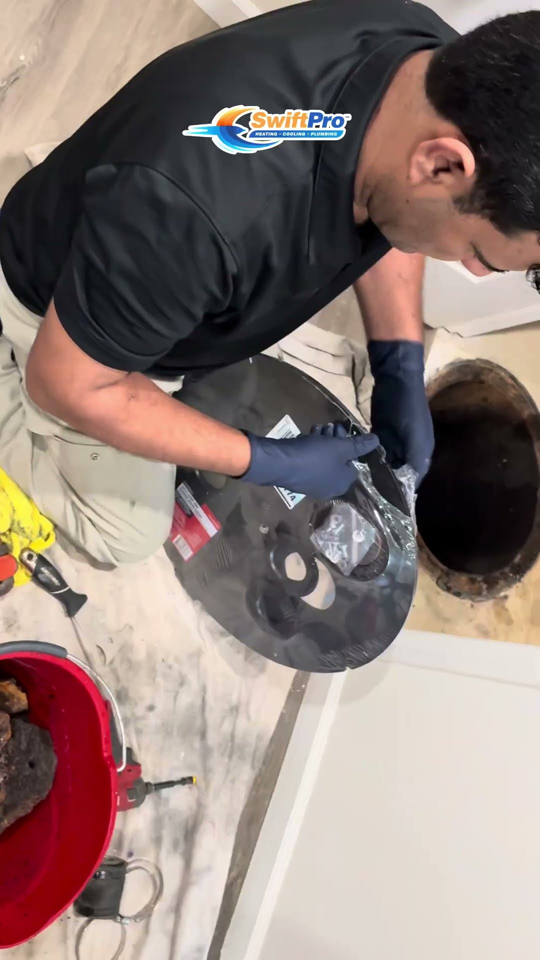 A red bucket full of black sludge and debris pulled from a sump pit.