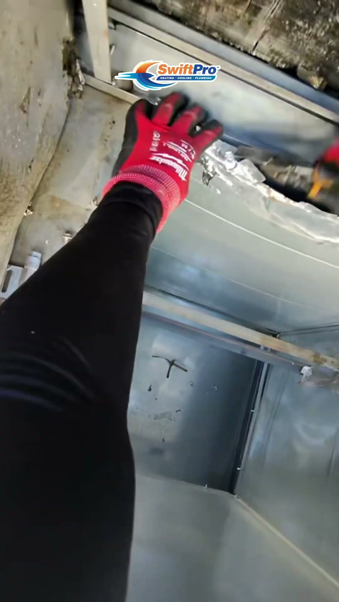 First-person view inside an air handler cabinet and plenum: a gloved hand checks the seams, a Milwaukee light inspects the corners, and foil tape and sealant close gaps around the coil.