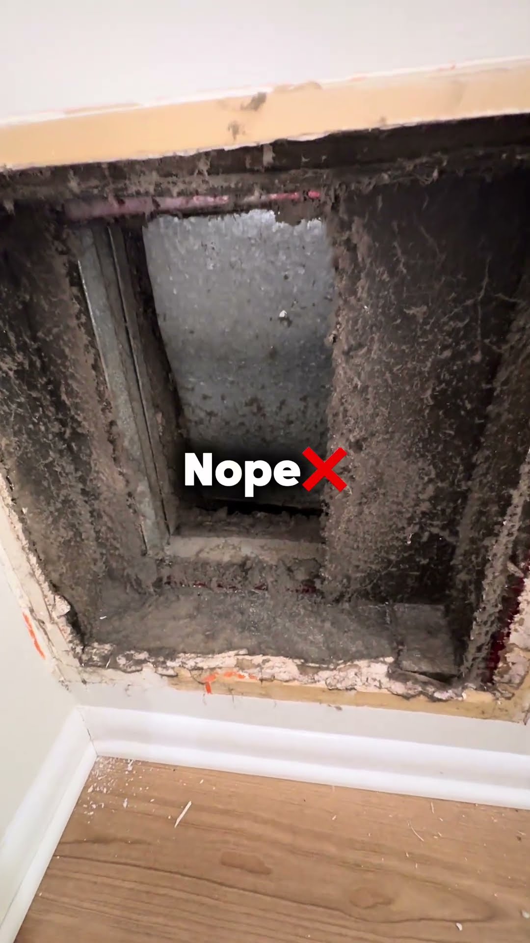 A wall return duct opening caked with thick gray dust, marked Nope.