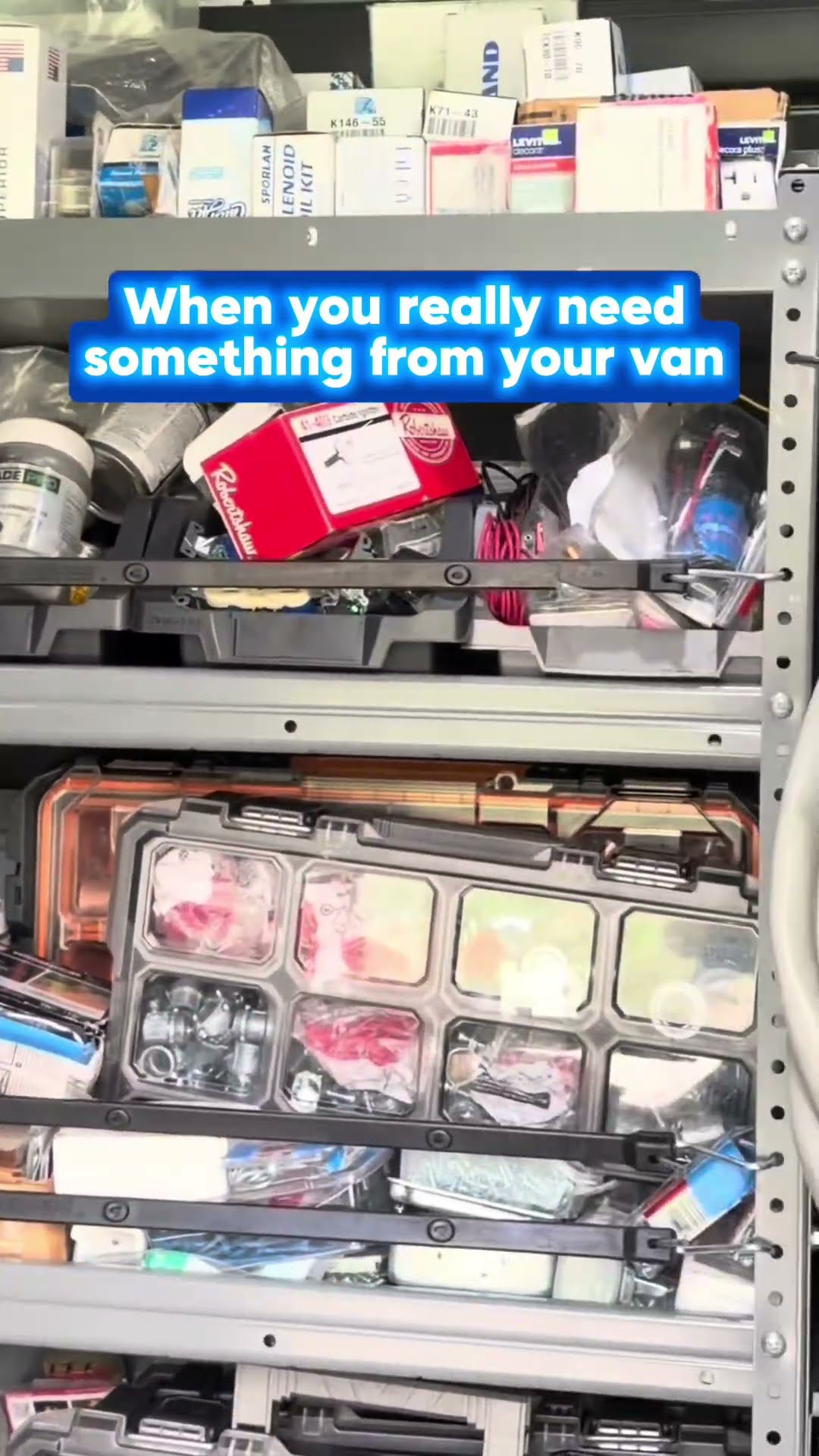 Inside a service van: stacked red Milwaukee Packout boxes and steel shelving packed with parts (solenoid coil kits, Sporlan parts, organizer bins).