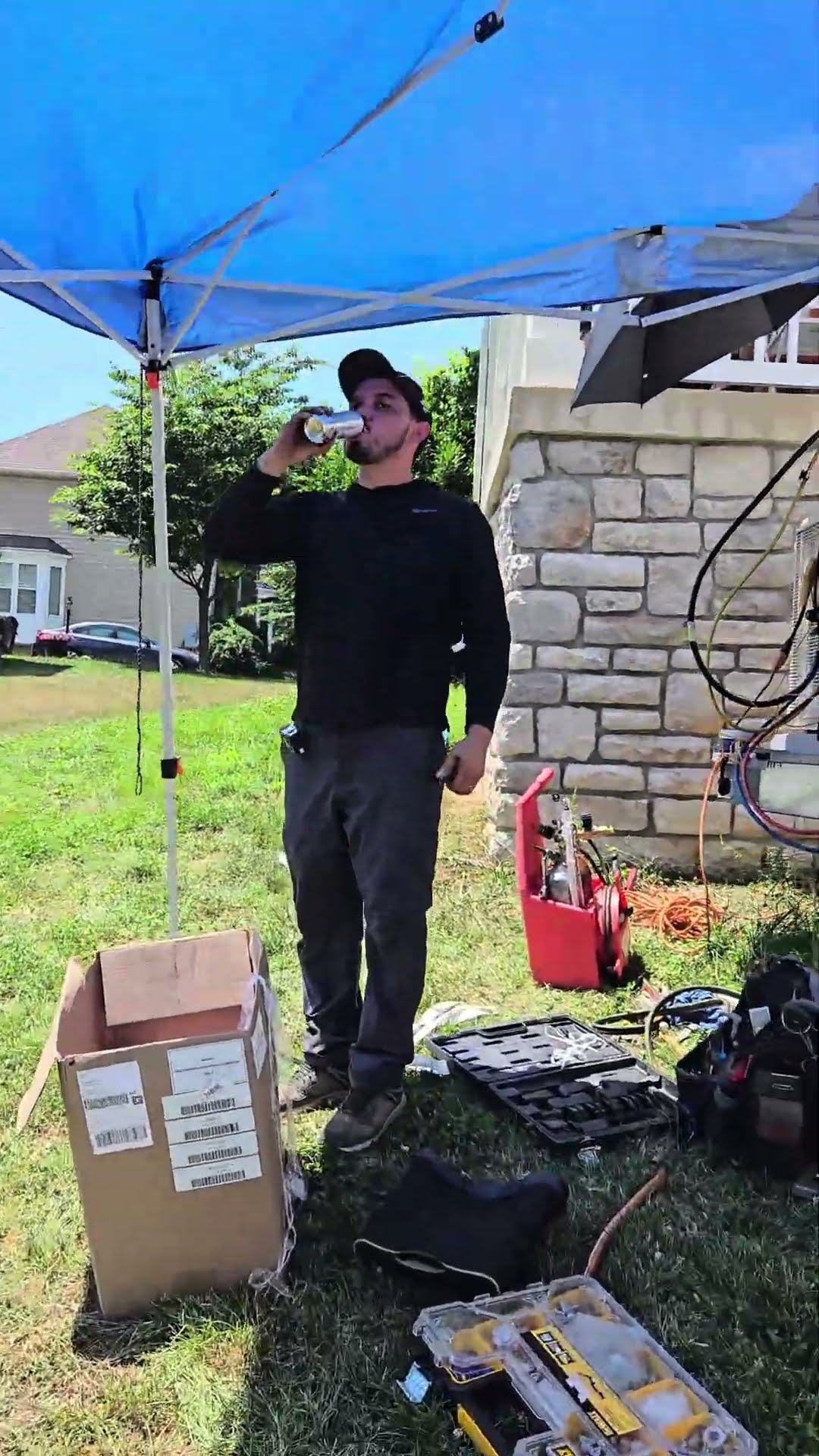 Crew moments: a bald bearded tech in a grey Carhartt t-shirt beside the SwiftPro van wrap, a tech drinking from a can under a blue pop-up tent in a yard with a boxed unit and tool cases, and a smiling