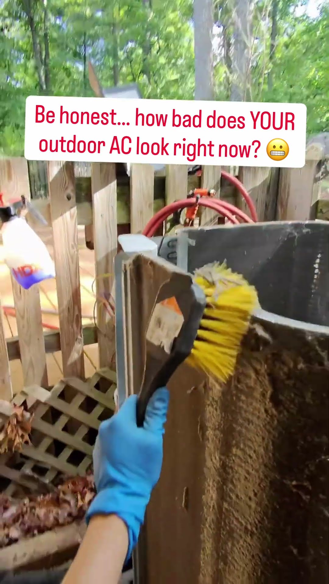 A blue-gloved hand scrubs a heavily dirt-matted outdoor AC coil with a yellow brush beside a wooden fence, captioned 'Be honest...
